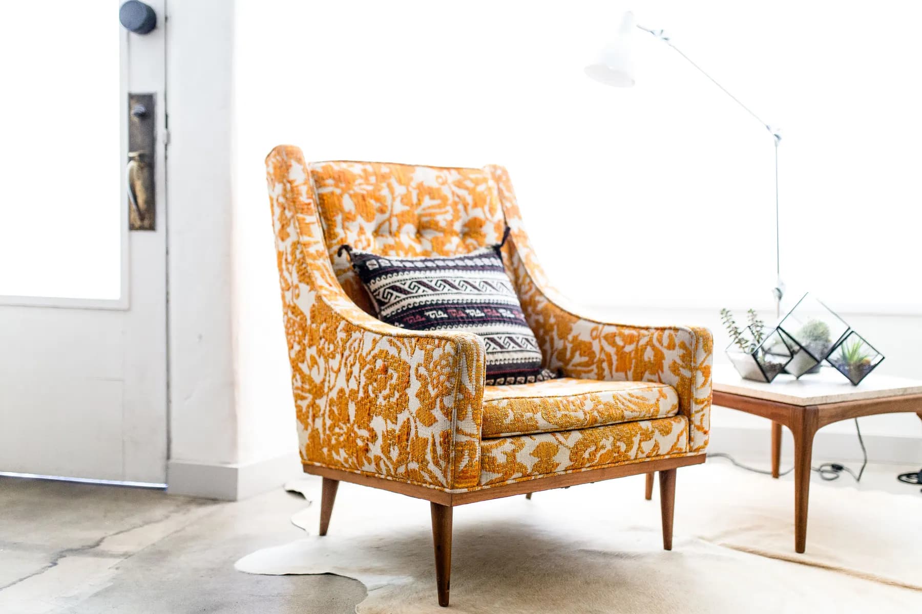 A patterned armchair beside a bright window in a calm room